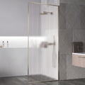 Modern bathroom with glass shower enclosure, gray tiles, and a bathtub.