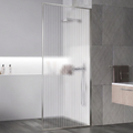 Bathroom with a glass shower door, tiled walls, and bathroom products.