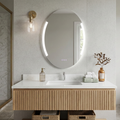 Bathroom vanity with round mirror, light fixture, and decorative elements.