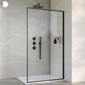 Modern shower setup with glass door, shower head, and controls in a tiled bathroom.