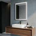 Bathroom vanity with a mirror, sink, and toiletries against a gray wall.