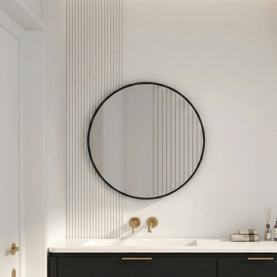 Round mirror with black frame on a white wall above a bathroom vanity.
