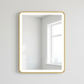 Rectangular mirror with a gold frame on a white wall