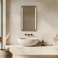 Bathroom with a modern sink and illuminated mirror on a tiled wall.