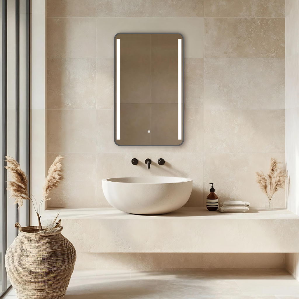 Bathroom with a modern sink and illuminated mirror on a tiled wall.