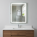Bathroom vanity with a large illuminated mirror above a sink.