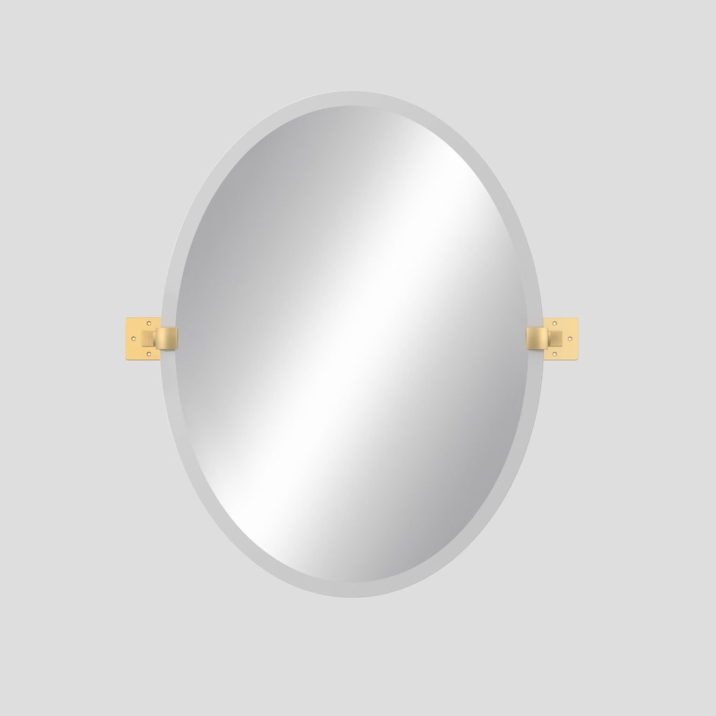 Oval mirror with gold brackets on a light gray background
