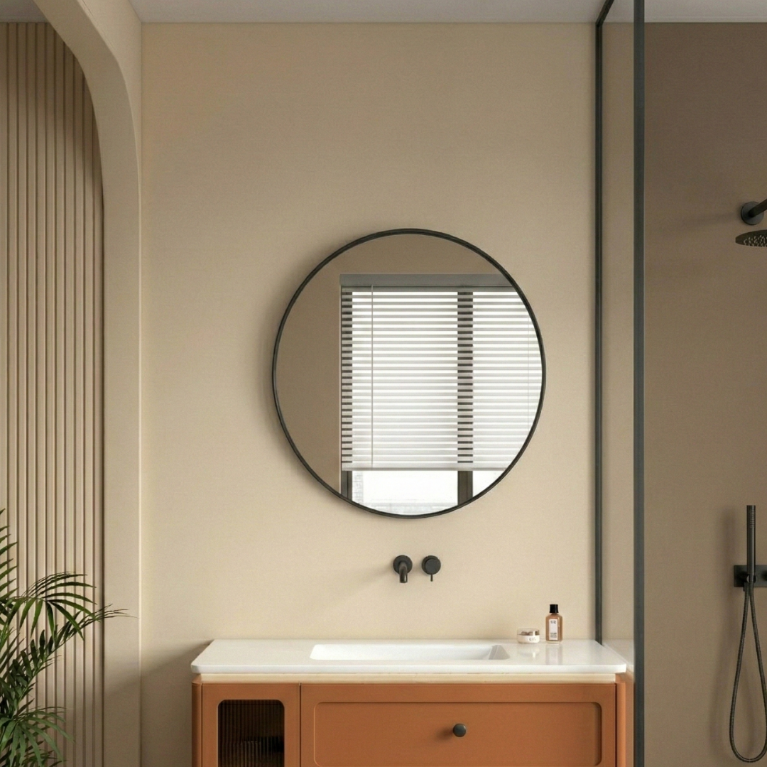 Bathroom interior with a round mirror, sink, and wooden cabinet.