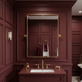 Bathroom with maroon walls, gold fixtures, and a mirror.