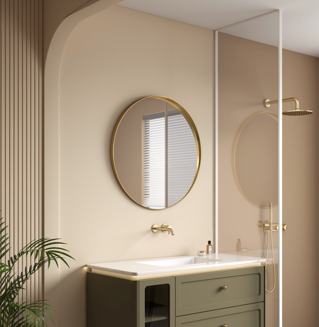 Modern bathroom with round mirror, sink, and shower area.